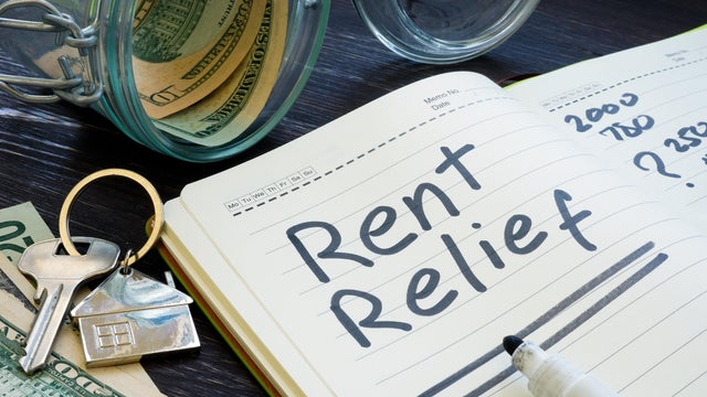 Rent relief sign and almost empty jar with money. 