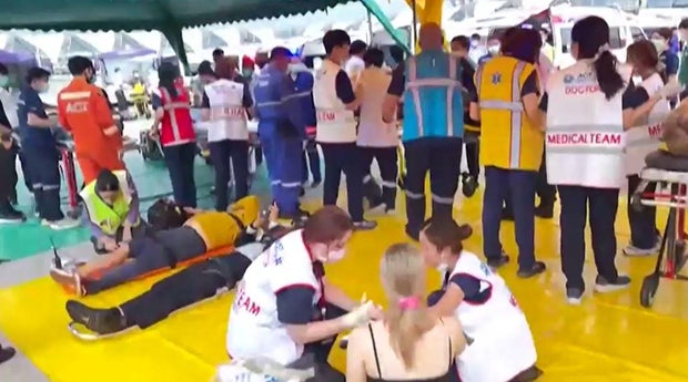 Emergency medics assess and treat people affected by severe turbulence on board Singapore Airlines Flight SQ321, in a triage area at Bangkok's Suvarnabhumi Airport, May 21, 2024, after the flight from London to Singapore was diverted to the Thai airport. 
