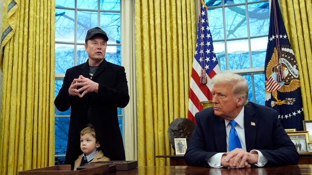 President Trump listens as Elon Musk, joined by his son, speaks in the Oval Office of the White House in Washington, D.C., on Tuesday, Feb. 11, 2025. 