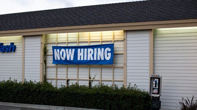 A NOW HIRING sign 