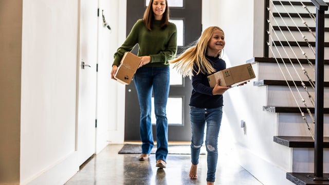 Young girls bringing delivery package into home 