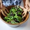 Female hands mixing various vegetable in wooden salad bowl. 